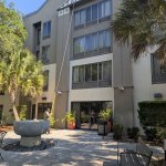 Professional soft washing technician cleaning a two-story house in Brandon, Tampa Florida using low-pressure equipment and eco-friendly solution