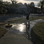 Professional pressure washing Valrico results showing clean concrete driveway and siding